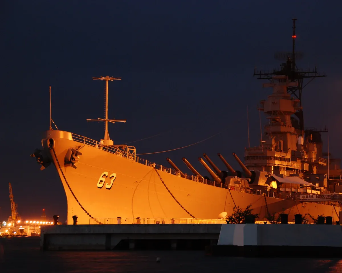 Battleship USS Missouri lit at night at Ford Island, a stop on Pearl Harbor tours from Honolulu